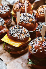 A large set of many hamburgers, cheeseburgers laid out on the table. Seth fast food. Food background, copy space.