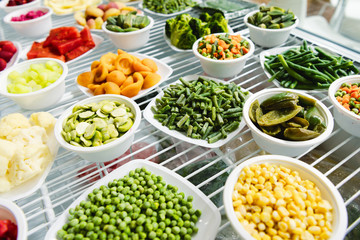 A variety of frozen foods lie in white cups.