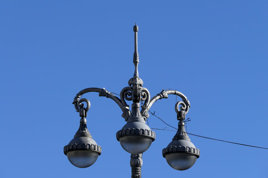 Gray old style retro street lamps and blue sky