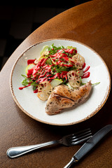 Top view of roasted turkey garnished with arugula salad with fresh green apple and cranberry sauce