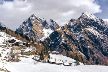 The traditional architecture of the Walser villages in the valleys of Monte Rosa, during a fantastic winter day, near the town of Alagna, Italy - February 2020.