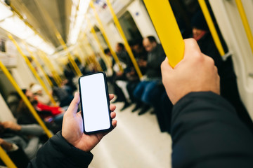 Closeup detail of a man using mobile phone inside public transport bus or subway