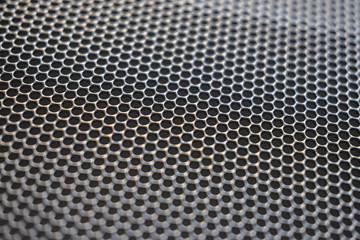 Metal background with round holes perforation, net of circles texture