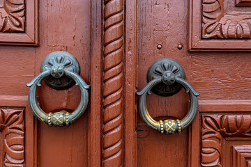 Red wooden door with two round metal handles