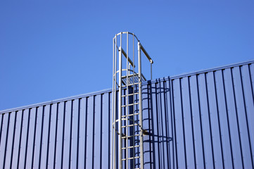 Blue background metal wall siding, cladding with stairs to the roof.