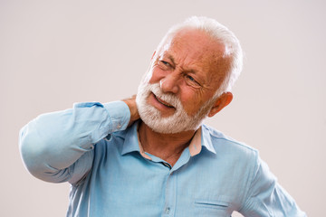 Portrait of senior man who is having pain in neck.