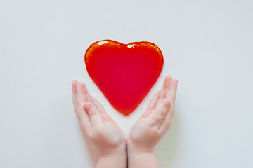 Slime heart in the hands. Sticky mucus in the hand. The child wrinkles the mucus in his hands. Favorite toy for a child. DIY starch is a soft, touch-friendly anti-stress trainer.