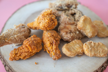 Crispy fried chicken on wooden tray.
