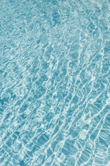 Surface of blue shining swimming pool water ripple. Perfect as a background for summer, vacation, calmness, serenity or any other idea.