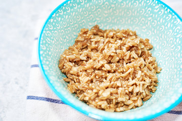 top view of cooked oatmeal in a blue plate with a pattern, healthy breakfast