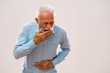 Portrait of senior man who is having pain in stomach.