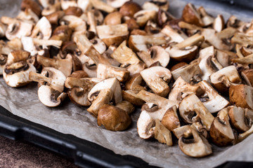A portion of fresh chopped mushrooms on a baking sheet before baking.