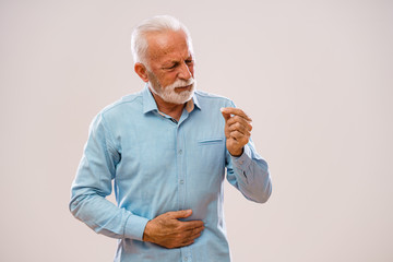 Portrait of senior man who is having pain in stomach.