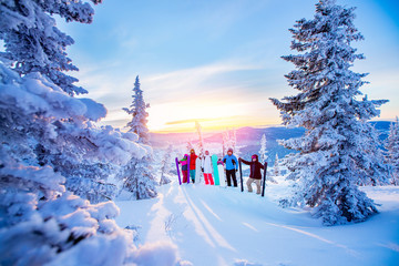Group friends with ski and snowboard on winter holidays. Skiers having fun on forest snow Sunrise...