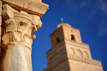 Fototapeta premium Close-up on a column in the courtyard of the Great Mosque of Kairouan, Tunisia, with the minaret in the background