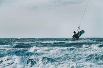Kite surfing in storm in winter with extreme high jumps.