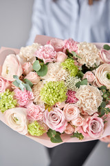 European floral shop. Beautiful bouquet of mixed flowers in womans hands. the work of the florist at a flower shop. Delivery fresh cut flower.