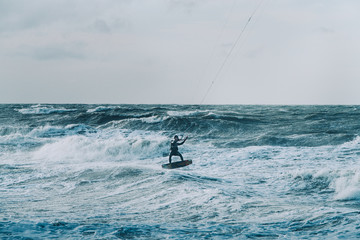 Kite surfing in storm in winter with extreme high jumps.