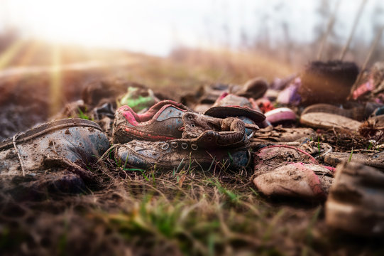 Old sneakers abandoned on gravel floor,Worn shoes,Soft focus.