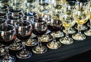 Red and white wine glasses in a row. Beverage catering service