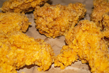 Chicken wings fried in breadcrumbs on a grey paper background. Close up.