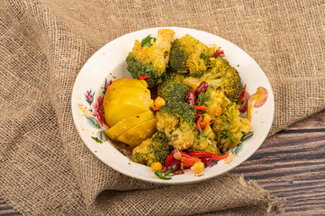 Vegetable salad in a white ceramic plate on a background of rough homespun fabric. Close up.