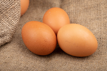 Chicken eggs on a background of rough homespun fabric. Homemade preparations, rustic treats. Close up.