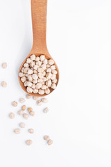 Chickpeas on wooden spoon on  white background. Top view.