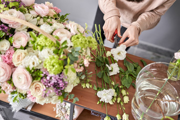 Education in the school of floristry. Master class on making bouquets. Summer bouquet in a wicker basket.. Learning flower arranging, making beautiful bouquets with your own hands. Flowers delivery