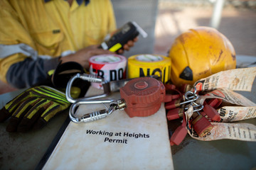 Working at heights permit book placing on the table an inertia reel shock absorbing fall protection...