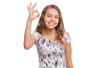 Portrait of teen girl making Ok Gesture, isolated on white background. Beautiful caucasian young teenager smiling and giving OK sign. Happy cute child showing okay.