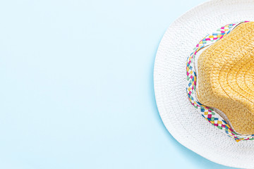 Fototapeta na wymiar Straw hat on pastel blue background. Summer concept. Top view, flat lay, copy space.