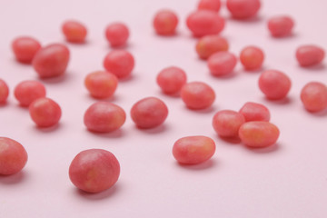 The concept of minimalism. Background from delicious bright pink candies on a bright pink background.