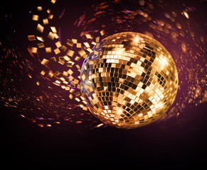 Golden mirror ball turning in disco ceiling and breaking into fragments