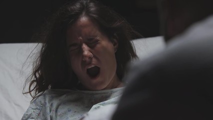 difficult childbirth and contractions in young woman, severe pain, loud scream, mother in labor in maternity ward gives birth to child or baby - Powered by Adobe