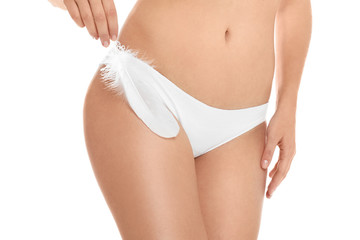 Woman with feather showing smooth skin on white background, closeup. Brazilian bikini epilation - obrazy, fototapety, plakaty