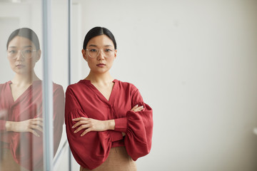 Waist up portrait of successful Asian businesswoman posing confidently standing with arms crossed...