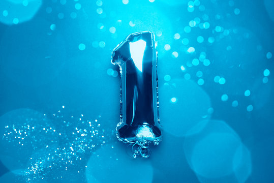 Silver Number Balloons with number One 1. Holiday Party Decoration or postcard concept with top view on blue background with bokeh lights