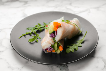 Delicious rolls wrapped in rice paper served on marble table