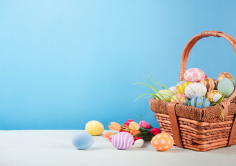 Happy easter, Easter painted eggs in the basket on wooden rustic table for your decoration in holiday. copy space.