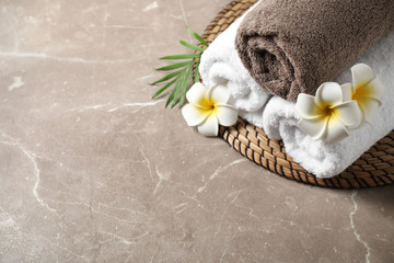 Beautiful spa composition with plumeria flowers on grey marble table, above view. Space for text - obrazy, fototapety, plakaty