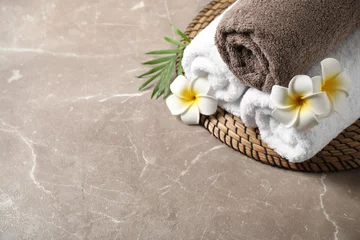 Deurstickers Beautiful spa composition with plumeria flowers on grey marble table, above view. Space for text © New Africa