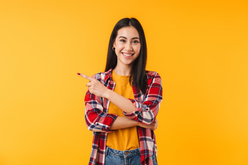 Image of happy attractive woman smiling and pointing finger aside