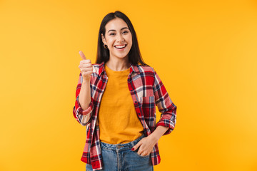 Image of joyful attractive woman smiling and showing thumb up