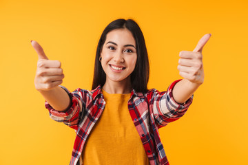Image of joyful attractive woman smiling and showing thumbs up