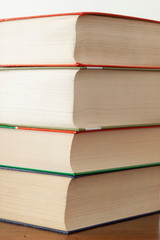 stack of piled books rest on a wooden table with copy space for your text