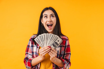 Image of excited woman holding dollars and expressing surprise