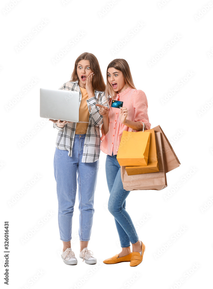 Sticker Surprised young women with laptop and shopping bags on white background