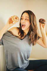 Pretty woman holding chocolate donuts. Food concept.
