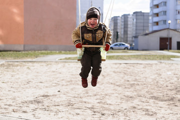 child on a swing in the playground in spring